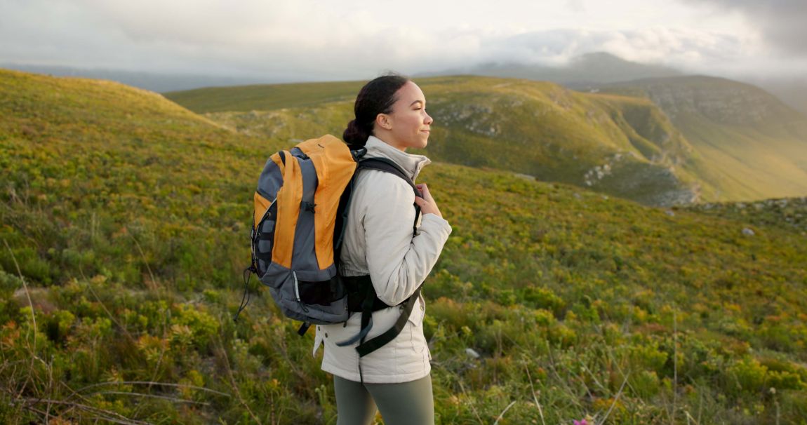 Asthma-inhaler woman hiking through green hills