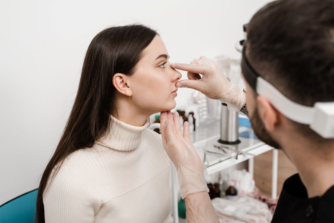 Facial-Plastics-Rhinoplasty-Consultation surgeon measuring patient's nose for rhinoplasty